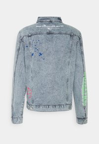 Jeansjacka i ljusblått med klassisk passform. Har blåa färgsplatter och tryckta detaljer i grönt och rosa på baksidan och ärmarna.