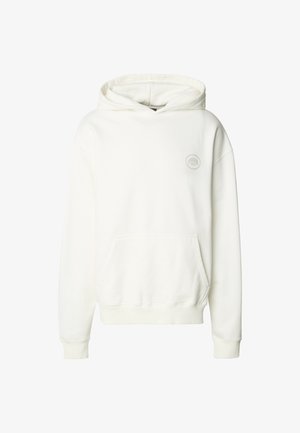 Hvit hettegenser laget av mykt stoff, med frontlomme, ribbede mansjetter og et rundt logopatch på brystet. Jevn tekstur.