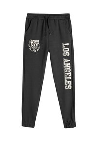 Pantalones de chándal negros hechos de una mezcla de algodón. Cuentan con una cinturilla elástica, bolsillos laterales y diseños estampados: "Campeones 1978" y "Los Ángeles."