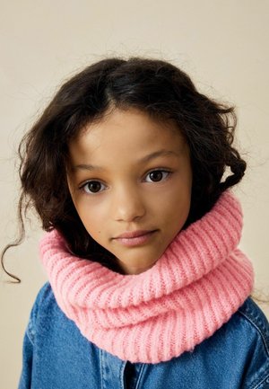 Scialle a collo in maglia a costine rosa avvolge il collo, abbinato a una giacca di denim. Texture morbida con un aspetto spesso e accogliente.