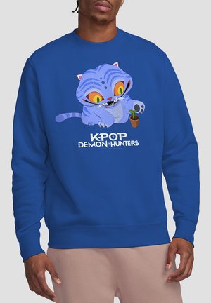 Blauer Hoodie mit einer cartoonhaften Katze mit großen gelben Augen, die eine kleine Pflanze hält. Darunter steht in weißem Text "KPOP DEMON HUNTERS".