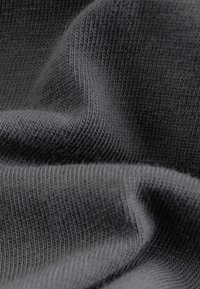 Sötétszürke kötött anyag sima textúrával, finom, egyenletes bordázattal és enyhe hullám mintázattal. Puha és rugalmas anyag.