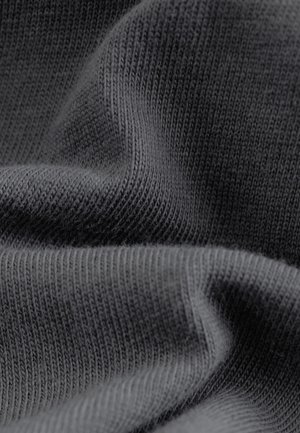 Tamsiai pilka mezgimo medžiaga su lygiu paviršiumi, pasižymi smulkia, vienoda ribbing ir subtiliais bangų raštais. Minkšta ir lanksti medžiaga.