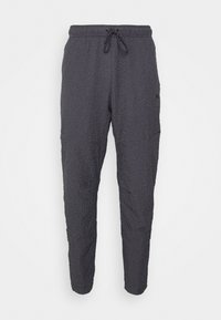 Pantalones ligeros de color gris oscuro con tela texturizada, cintura elástica y cordón ajustable. Presentan piernas ajustadas y bolsillos laterales.