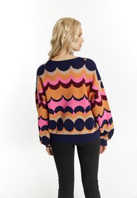 Maglione lavorato a maglia con motivi a onde multicolori in rosa, arancione e blu navy. Vestibilità ampia con polsini e orlo a coste, progettato per il massimo comfort.