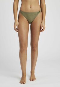 Bas de bikini vert kaki en tissu texturé, avec une ouverture de jambe décolletée, et un détail en torsion sur le côté. Design minimaliste et finitions douces.