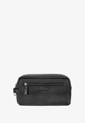 Czarna skórzana prostokątna kosmetyczka z przednią kieszenią na zamek, naszywką z logo i boczną pętlą do uchwytu na białym tle.