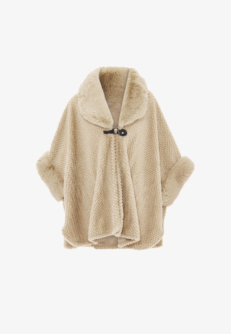 Beige fleecetunika, jossa on herringbone-kuvio, ylisuuri kaulus ja rullatut hihansuut; kiinnitetään mustalla napilla ja silmukalla.