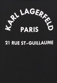 Černé bavlněné tričko s výrazným bílým nápisem: "KARL LAGERFELD PARIS" zahnutým do oblouku a "21 RUE ST-GUILLAUME" v přímé linii pod ním.