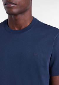 T-shirt in cotone blu navy con scollatura rotonda e maniche corte. Presenta un piccolo logo ricamato azzurro sul petto.