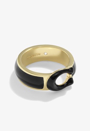 Złoty pierścionek z czarną emalią o otwartym wzorze "C" z przodu i małym osadzonym kamieniem szlachetnym wewnątrz obrączki.