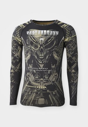 Chemise à manches longues noire avec un design graphique audacieux représentant un visage squelettique et des éléments mécaniques dans des tons de gris et d'or.