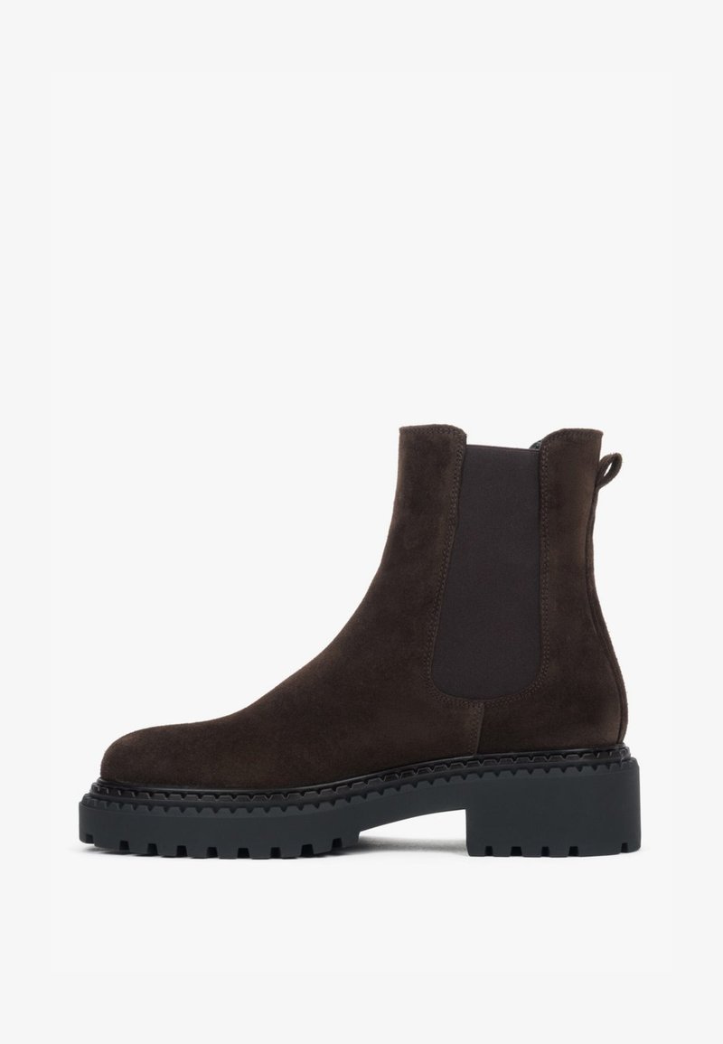 Brązowe zamszowe botki za kostkę z elastycznymi panelami po bokach, teksturowaną cholewką, masywną czarną gumową podeszwą oraz pętelką z tyłu ułatwiającą zakładanie.