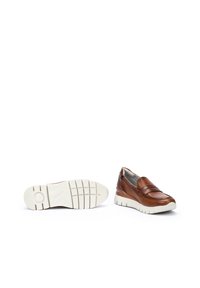 Zapatos de piel marrón tipo slip-on con superficie texturizada, cuello acolchado y suela de goma blanca con un patrón de banda de rodadura segmentado.