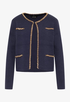 Cárdigan de punto azul marino con acentos de cadena dorada en el escote y los bolsillos frontales, con un diseño corto y mangas largas.
