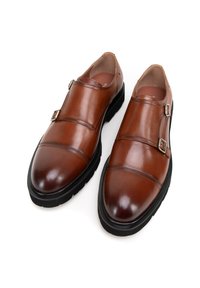 Bruine leren schoenen met een gladde afwerking, voorzien van twee gespen, een ronde neus en een zwarte rubberen zool. Subtiele stikdetails op het bovenwerk.