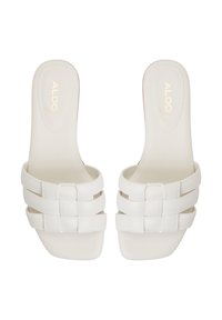 Vita platta slidesandaler med fyrkantig tå och vävda remmar, med guld "ALDO"-logo på innersulan.