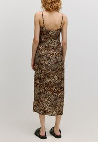Leopardenmuster Midi-Kleid mit dünnen, verstellbaren Trägern, tailliertem Design und glattem Stoff. Verfügt über einen geraden Saum und eine lockere Passform. Schwarze Sandalen.