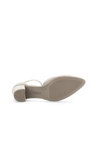 High-heeled shoe with a smooth, light beige suede upper, open back design, and rubber outsole featuring a patterned grip for traction.