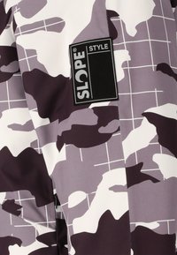 Violetti camohousutakki, jossa on ruudullinen kuvio, valmistettu sileästä materiaalista, edessä musta "SLOPE STYLE" -merkki.