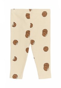 Beige hladké legíny s potiskem sušenek v hnědé barvě, včetně celých a půl sušenek, se drobnými čokoládovými kousky.