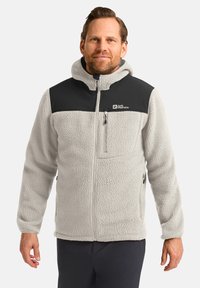 Giacca in pile grigia chiara con pannello superiore nero, zip completa e tasca sul petto con zip. Presenta un esterno testurizzato e colletto rialzato.