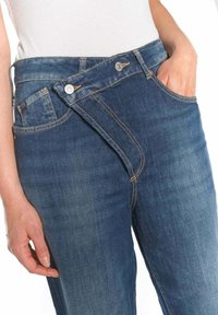 Denim jeans met een hoge taille, unieke schuine ritssluiting, lichtblauwe kleur en contrasterende stiksels. Voorzien van zijzakken en een soepele textuur.