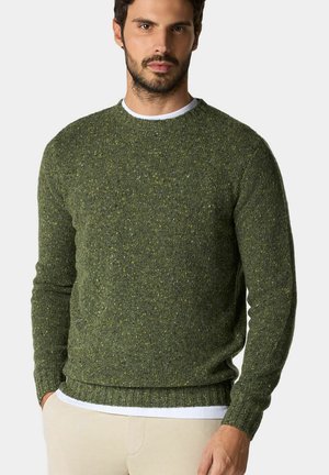 Gebreide trui in donkergroen met een gestructureerd oppervlak, verfraaid met gele spikkels. Ribgebreide manchetten en zoom, ronde halsontwerp, gedragen over een witte shirt.