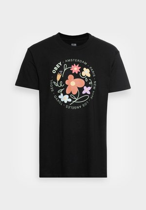 Czarny t-shirt z wielokolorową grafiką kwiatu i tekstem wymieniającym miasta, w tym Amsterdam, Paryż, Nowy Jork, Tokio, Seul i Los Angeles.