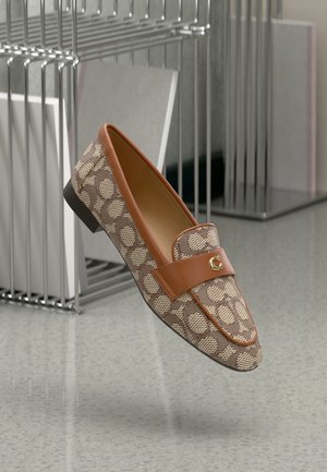 Brown patterned loafers with a tan leather strap, featuring a gold logo accent and a low black heel against a minimalist background.