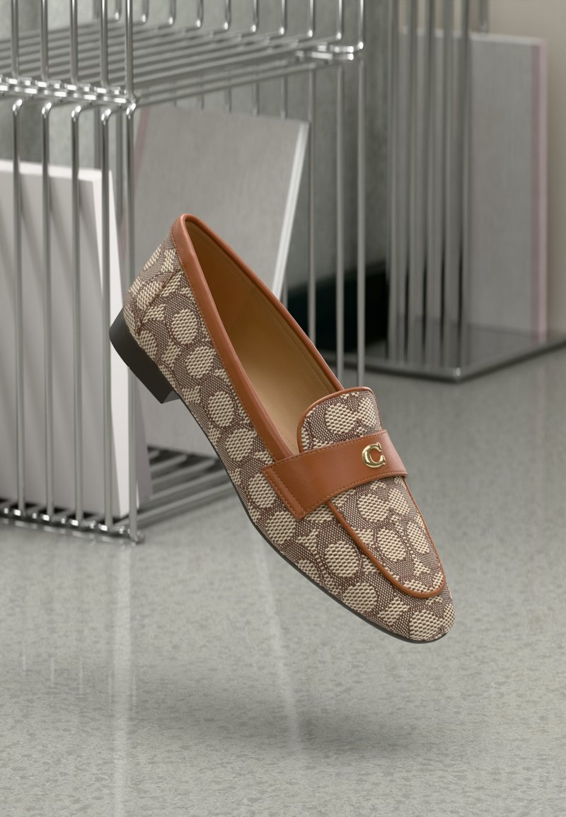 Brown patterned loafers with a tan leather strap, featuring a gold logo accent and a low black heel against a minimalist background.