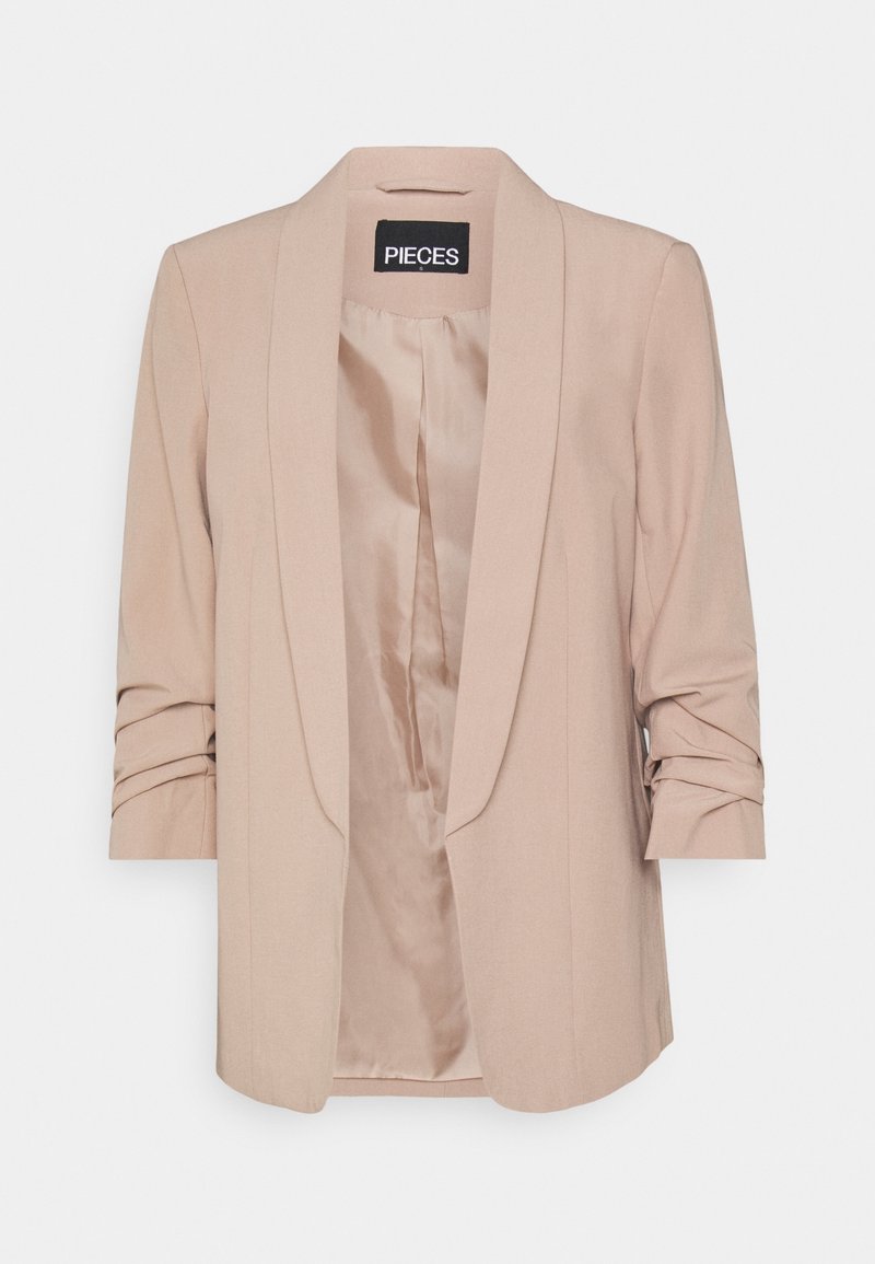 Blazer beige con collo sciallato, silhouette strutturata, maniche arrotolate e fodera interna liscia. Etichetta del brand visibile all'interno.