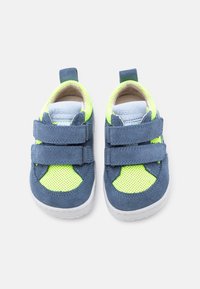 Παπούτσια για νήπια με μπλε σουέντ και νέον κίτρινο δίχτυ, με διπλά λουράκια βέλκρο και λευκές σόλες, τοποθετημένα δίπλα-δίπλα.