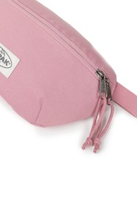 Sacca in tessuto rosa con una superficie texturizzata, chiusura a doppia zip e un piccolo etichetta del marchio. Include un cordino ad anello sulla zip.