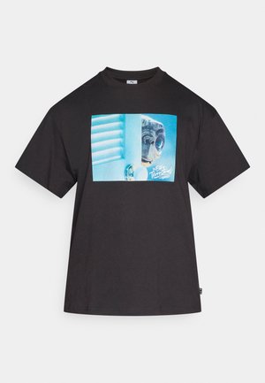 Czarny bawełniany t-shirt z grafiką na przodzie przedstawiającą postać patrzącą przez częściowo otwarte drzwi z żaluzjami, w niebieskich odcieniach.