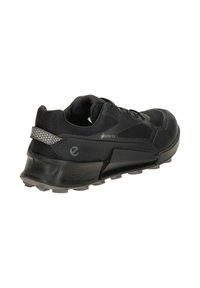 Black athletic shoe featuring a textured upper, cushioned sole, and reflective accents. Waterproof Gore-Tex material for durability.