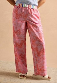 Rote, locker sitzende Hosen in Pink mit einem maritimen Muster, ausgestattet mit einem gestreiften elastischen Bund. Hergestellt aus leichtem Stoff für maximalen Komfort.