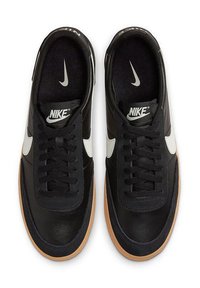 Μαύρα δερμάτινα αθλητικά παπούτσια με λευκό σήμα Nike, μαύρες κορδόνες και σόλα από καουτσούκ καραβόπανο. Το εσωτερικό είναι επενδεδυμένο με μαλακό μαύρο ύφασμα.