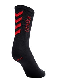 Czarna skarpetka o prążkowanej fakturze, czerwona jodełka w pobliżu górnej krawędzi oraz napis „FECKÖLÜN” na boku w czerwonym kolorze, zaprojektowana dla wygody i wsparcia.