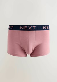 Rosa bomullboxershorts med en elastisk marinblå midjeband som har "NEXT" i rosa bokstäver. Slät textur och figurnära design.