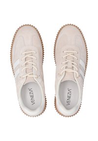 Beige Wildleder-Sneaker mit weißen Streifen, runder Zehenpartie und strukturiertem Gummisohle. Schnürdesign mit verstärkten Ösen.