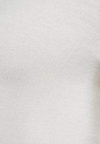 Bílá, hladká tkanina s jemnou strukturou, vykazující jemné a rovnoměrné tkanie bez viditelných vzorů nebo akcentů.