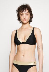 Svart bikinisett med dyp utringning, gullfargede detaljer på stropper og liv, samt en jevn og elastisk tekstur.