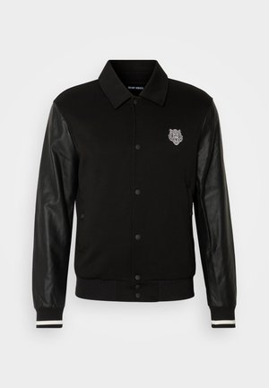 Black jacket with fabric body and leather sleeves. Features a button front, striped ribbed cuffs, and an embroidered logo on the chest.