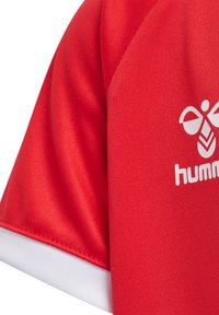 Rode sporttrui met korte mouwen, een witte bies en een logo in het wit op de voorkant gedrukt. De stof lijkt soepel en ademend te zijn.