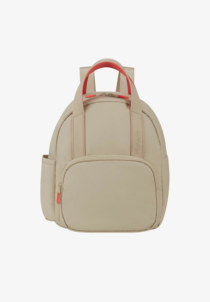 Beige backpack with a rounded design, dual pink straps, a front zip pocket, and a side mesh pocket. Textured fabric with a smooth finish.