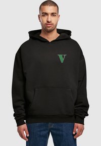 Sort hoodie lavet af bomuld med en frontlomme. Har et grønt 'V' logo på venstre bryst. Afslappet pasform med en stor hætte.