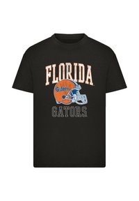Schwarzes Baumwoll-T-Shirt mit orangefarbenem und weißem Text: "FLORIDA Gators" über einer Grafik eines blauen Football-Halstes. Einfaches Crewneck-Design.