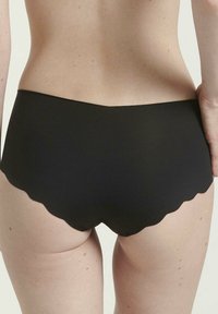 Schwarze hochgeschnittene Bikiniunterteile mit gewelltem Rand. Glatte Textur und minimalistisches Design, das sich auf Komfort und Passform konzentriert.