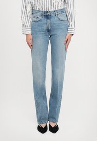 Ανοιχτό μπλε τζιν παντελόνι με ίσια γραμμή. Διαθέτει πέντε τσέπες, κλείσιμο με κουμπί μπροστά και διακριτική φθορά στα πόδια.